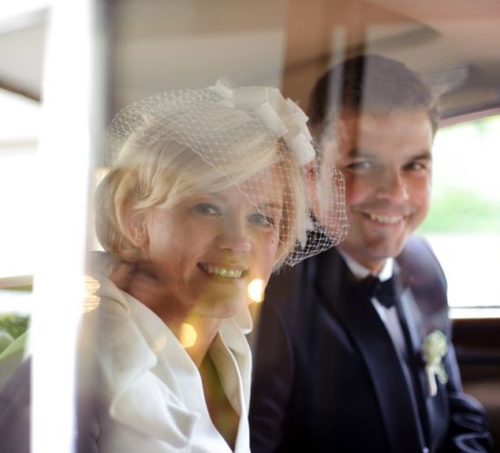Brautpaar schaut aus dem Hochzeitsauto
