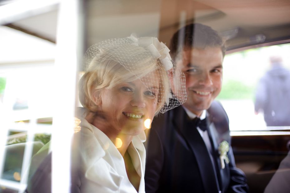 Brautpaar schaut aus dem Hochzeitsauto