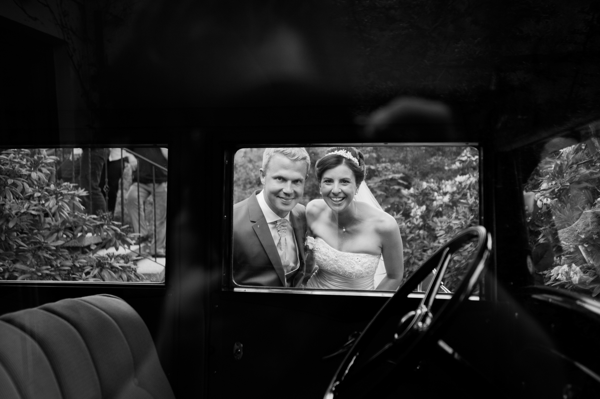 Brautpaar schaut in den Hochzeits-Oldtimer