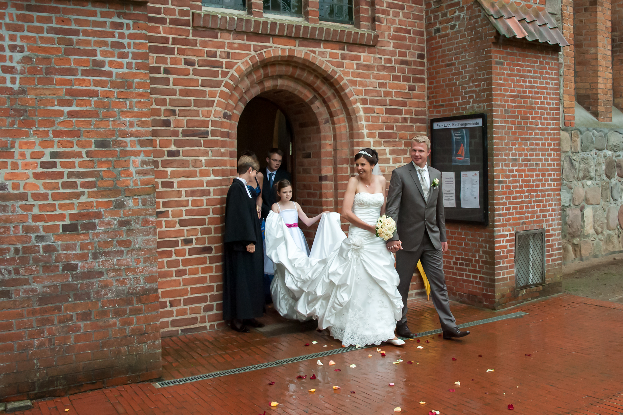 Brautpaar verlässt die Kirche bei Regen